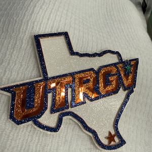 A close-up of a glittery, glittery logo on a white background.