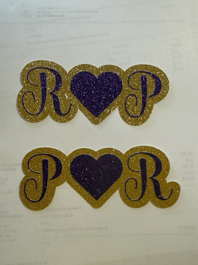 two glittery heart-shaped objects with the letters "R" and "P" on them, placed on a white background.