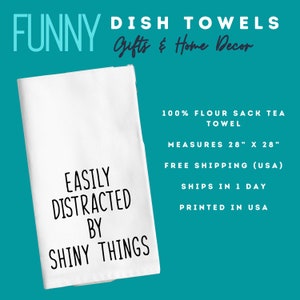 May include: White flour sack tea towel with the text "EASILY DISTRACTED BY SHINY THINGS" in black. The towel measures 28" x 28". The words "FUNNY DISH TOWELS Gifts & Home Decor" are at the top.