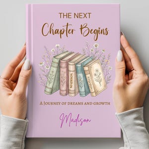 May include: A lavender-colored book cover with the text "The Next Chapter Begins" in brown script. Below, the text "A Journey of Dreams and Growth" and the name "Madison" are displayed. The cover features illustrations of books and flowers.