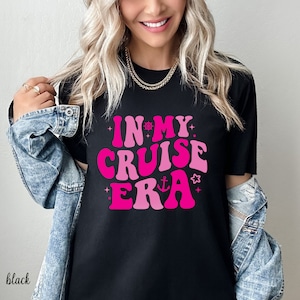 Puede incluir: Camiseta negra con un gráfico rosa que dice "In My Cruise Era" con una estrella y un ancla náutica.