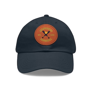 May include: A navy blue baseball cap with a brown leather patch featuring a baseball logo with the text "MILWAUKEE EST. 1969 BASEBALL".