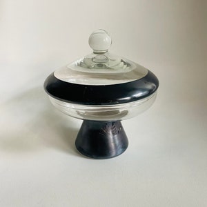 May include: A clear glass candy dish with a black band around the top and a black pedestal base.