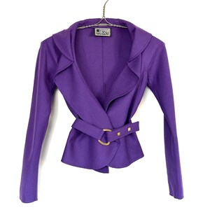 Pode incluir: Um casaco roxo vibrante com um design envolvente e um cinto a condizer com fivela dourada. O casaco tem mangas compridas e gola entalhada. A etiqueta diz "Gianni Versace".