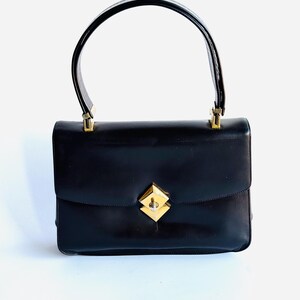 Bolso vintage Koret de piel color chocolate con asa telescópica y cierre de solapa con herrajes dorados.