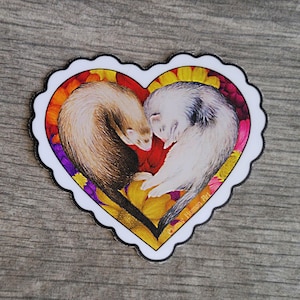 May include: A white heart-shaped sticker with a colourful floral design. Two brown and white ferrets are curled up together inside the heart. The text "Chums Human Pet" is at the bottom of the sticker.