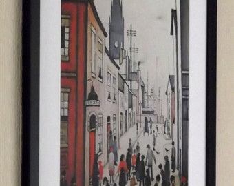 May include: A framed black and white print of a street scene with a crowd of people walking down a narrow street. The buildings are tall and narrow, and the street is lined with lampposts. The print is in a black frame.