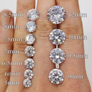 May include: A size comparison chart of round, clear, faceted gemstones. The gemstones range in size from 5mm to 12mm. The chart is labeled with the size of each gemstone in millimeters.