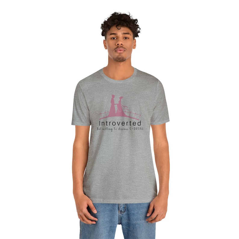 May include: A heather grey t-shirt with a pink silhouette of two people walking hand-in-hand. The text "Introverted But willing to discuss C-Drama" is printed below the silhouette.