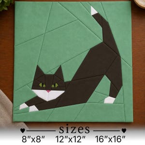 May include: A square wall art piece featuring a geometric cat design in black, white, and green. The cat is in a stretching pose against a green background with angular lines. Text below indicates available sizes: 8"x8", 12"x12", and 16"x16".