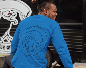 Op de afbeelding: Een koninklijkblauw longsleeve shirt met een zwarte afbeelding van een bergketen, zon en bomen in een cirkel met de tekst "explore more".