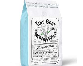 Puede incluir: Una bolsa blanca de granos de café con un borde azul. La bolsa presenta un logotipo con una cabra de dibujos animados y el texto "Tiny Goat Small Batch Coffee Roasters". El texto "The Spotted Goat" está impreso en negro sobre un fondo blanco. La bolsa también incluye el texto "Dark, Rich & Handsome" y "Fair Trade".