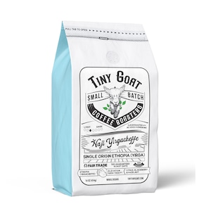 May include: A white bag of Tiny Goat Small Batch Coffee Roasters Haji Yirgacheffe single origin Ethiopia coffee. The bag features a cartoon goat and the text "100% Guaranteed Roast Date".