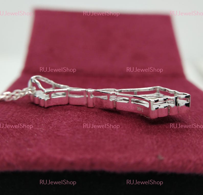 May include: A silver pendant necklace with a geometric design featuring multiple small clear stones. The pendant is on a silver chain.