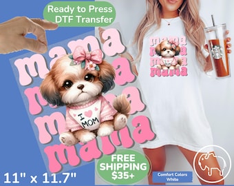 May include: A pink and white DTF transfer design featuring a cartoon dog with a pink bow and the word "mama" repeated in a pink, retro font. The design is 11 inches by 11.7 inches.