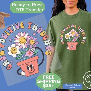 May include: A green t-shirt with a graphic of a flower pot with a smiling face and the text "Grow Positive Thoughts".
