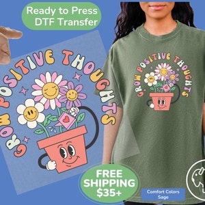 May include: A ready-to-press DTF transfer with a colorful graphic of a flower pot with a smiling face and the text "Grow Positive Thoughts".
