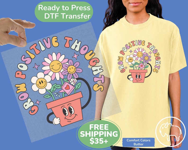 May include: A yellow t-shirt with a graphic of a flower pot with a smiling face and three flowers growing out of it. The text "Grow Positive Thoughts" is written in a rainbow-colored arc around the pot.