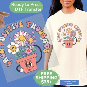 May include: A light pink and blue iron-on transfer design featuring a flower pot with a smiling face and the text "Grow Positive Thoughts".