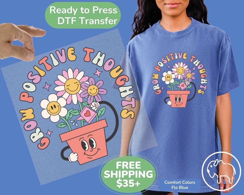 May include: A blue t-shirt with a graphic of a flower pot with a smiling face and the text "Grow Positive Thoughts".