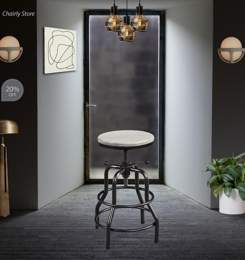 May include: A black metal swivel bar stool with a white wood top. The stool has a round seat and a footrest. The stool is in a room with a door and a light fixture.
