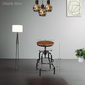 May include: A black metal adjustable height bar stool with a brown wooden seat. The stool is 51-69 cm tall and has a 33 cm diameter seat. The stool is 26 cm wide and has a 7.6 cm diameter base.