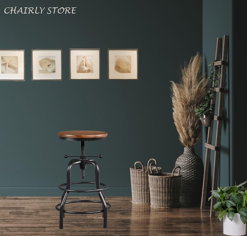 May include: A black metal bar stool with a wooden seat and a footrest. The stool has an adjustable height and a swivel base. The stool is in a room with a green wall and a wooden floor.