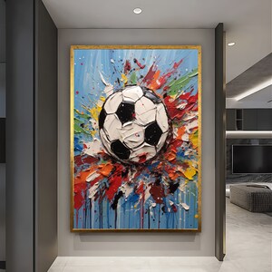 May include: A colourful abstract painting of a football with splashes of paint in shades of blue, green, yellow, red, and orange.