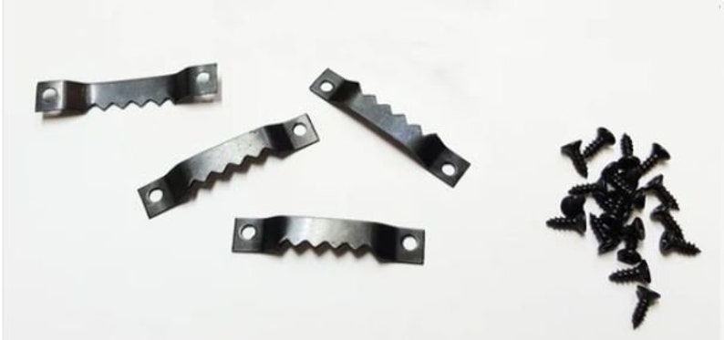 May include: A set of four black metal picture hanging hooks with a serrated edge and a set of black screws.