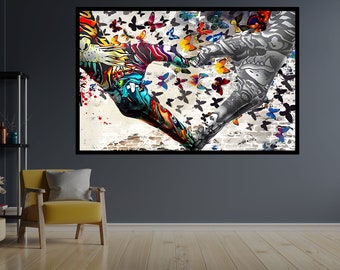May include: A framed art print featuring two arms forming a heart shape, one in vibrant colors and the other in grayscale. Butterflies of various colors and sizes surround the arms, set against a textured background with brick and paint splatters.