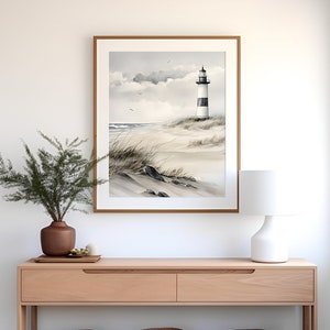 May include: A light wood console table with two drawers and a lower shelf. Three woven baskets are on the shelf. A framed watercolour painting of a lighthouse on a beach hangs on the wall above the table. A white lamp sits on the table.