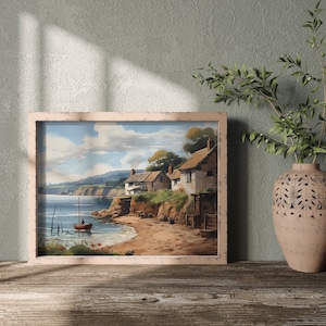 Könnte beinhalten: Ein gerahmtes Gemälde, das eine Küstenlandschaft mit einem kleinen Dorf, einem Boot im Wasser und einem Sandstrand zeigt. Das Gemälde ist in einem hellen Holzrahmen gefasst und hängt an einer Wand.