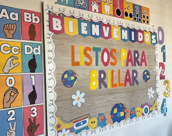 May include: A colorful bulletin board with the words "Bienvenidos Listos Para Brillar" in Spanish, which translates to "Welcome Ready to Shine". The board is decorated with colorful letters, numbers, and disco ball designs.