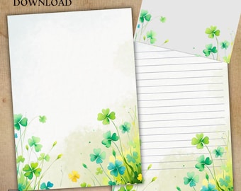 May include: Two sheets of stationery featuring watercolor illustrations of green clover leaves and stems at the bottom. One sheet is blank, while the other contains horizontal lines for writing. The background is a soft, light off-white color.