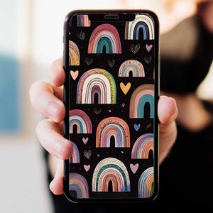 Könnte beinhalten: Ein Smartphone, das eine farbenfrohe Hintergrundtapete mit einem Muster aus Regenbögen und Herzen auf schwarzem Hintergrund zeigt.