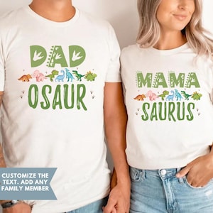 May include: White t-shirts with green dinosaur graphics and text that says "DAD OSAUR" and "MAMA SAURUS".
