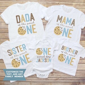 May include: White t-shirts and a onesie with matching designs for a family. Each shirt has a different title, such as "DADA", "MAMA", "SISTER", and "BROTHER", with the words "of the sweet ONE" and a cookie graphic. The onesie says "sweet boy JACKSON".