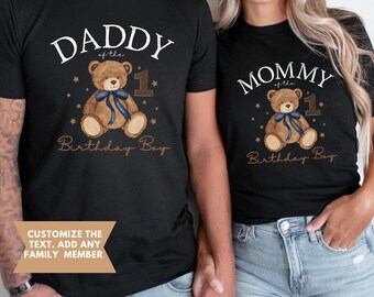 May include: Black t-shirts with matching designs. One shirt reads "DADDY of the Birthday Boy" with a teddy bear graphic and the number 1. The other shirt says "MOMMY of the Birthday Boy" with a similar design. Text at the bottom says "Customize the text. Add any family member."