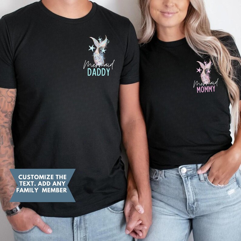 May include: Black t-shirts with mermaid tail and star graphics. One shirt says "Mermaid Daddy" in blue, the other says "Mermaid Mommy" in pink. The shirts are worn by a couple holding hands. Text on the bottom says "Customize the text. Add any family member."