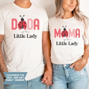 May include: White t-shirts with matching designs. One shirt reads "DADA of the Little Lady" with a ladybug graphic. The other shirt says "MAMA of the Little Lady" with a ladybug graphic. The text "Customize the text. Add any family member" is also visible.