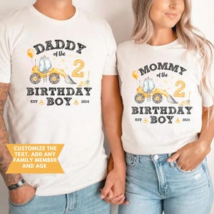 May include: Matching white t-shirts with a birthday theme. One shirt says "Daddy of the Birthday Boy 2024" with a yellow construction vehicle graphic. The other says "Mommy of the Birthday Boy 2024".