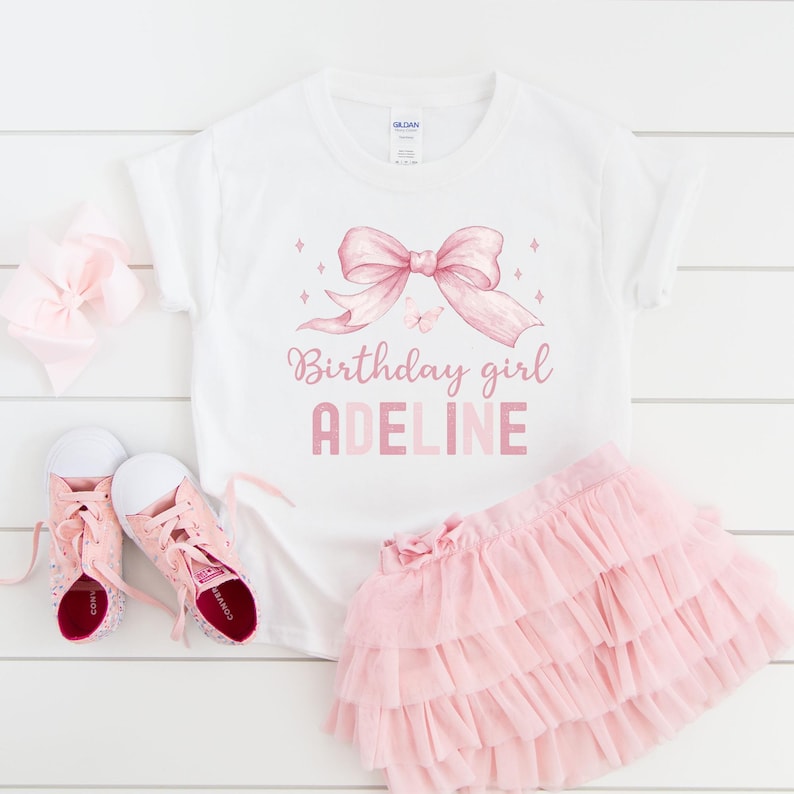 Puede incluir: Camiseta blanca con un lazo rosa y el texto "Birthday girl ADELINE".