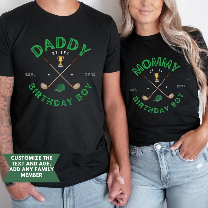 May include: Two black t-shirts with green text and graphics. The text on the shirts reads "Daddy of the Birthday Boy" and "Mommy of the Birthday Boy". The graphics are of crossed golf clubs, a golf ball, a golf cap, and a trophy.