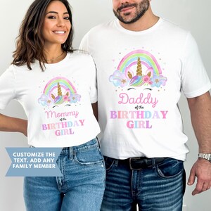 K&ouml;nnte beinhalten: Zwei wei&szlig;e T-Shirts mit einem Regenbogen- und Einhorn-Design. Der Text auf den Shirts lautet "Mommy of the Birthday Girl" und "Daddy of the Birthday Girl".