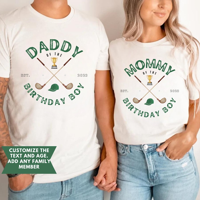 May include: White t-shirts with green text and graphics. The text on the shirts reads "Daddy of the Birthday Boy Est. 2023" and "Mommy of the Birthday Boy Est. 2023". The graphics include crossed golf clubs, a golf ball, and a golf hat.