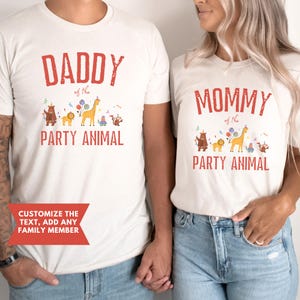 Peut inclure: Deux t-shirts blancs cass&eacute; assortis avec du texte rouge et des graphiques d'animaux. L'un dit "DADDY of the PARTY ANIMAL", l'autre "MOMMY of the PARTY ANIMAL". Les t-shirts ont une option de texte personnalisable.