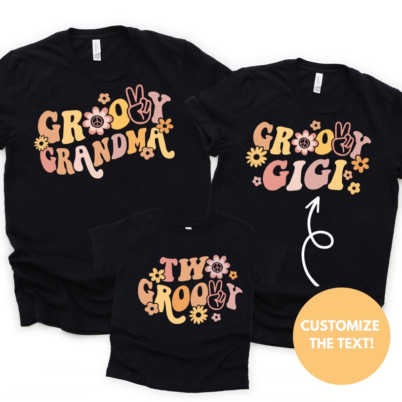 May include: Three black t-shirts with a groovy font design. The shirts say "Groovy Grandma", "Groovy Gigi", and "Two Groovy".