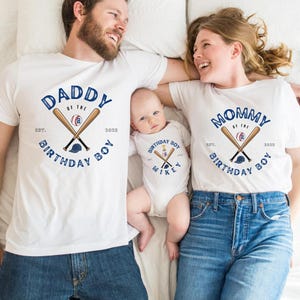 K&ouml;nnte beinhalten: Wei&szlig;e T-Shirts und ein Baby-Body mit Baseball-Motiven. Die Shirts tragen die Aufschrift "Daddy of the Birthday Boy" und "Mommy of the Birthday Boy" mit gekreuzten Schl&auml;gern und einem Baseball. Der Body tr&auml;gt die Aufschrift "Birthday Boy Mikey".
