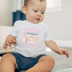 K&ouml;nnte beinhalten: Ein wei&szlig;es T-Shirt mit dem rosa Schriftzug "BROTHER of the Birthday girl" und einer Grafik von mehreren Zeichentrickhunden. Auf dem Shirt steht auch "LET'S PAWTY" in Rosa. Das Kind tr&auml;gt blaue Jeansshorts.