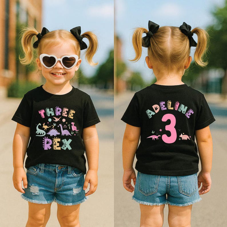 May include: A black t-shirt with the text "THREE REX" and dinosaur graphics in various colours. The child is wearing denim shorts and heart-shaped sunglasses. The back of the shirt has the name "ADELINE" and the number "3" with dinosaur graphics.